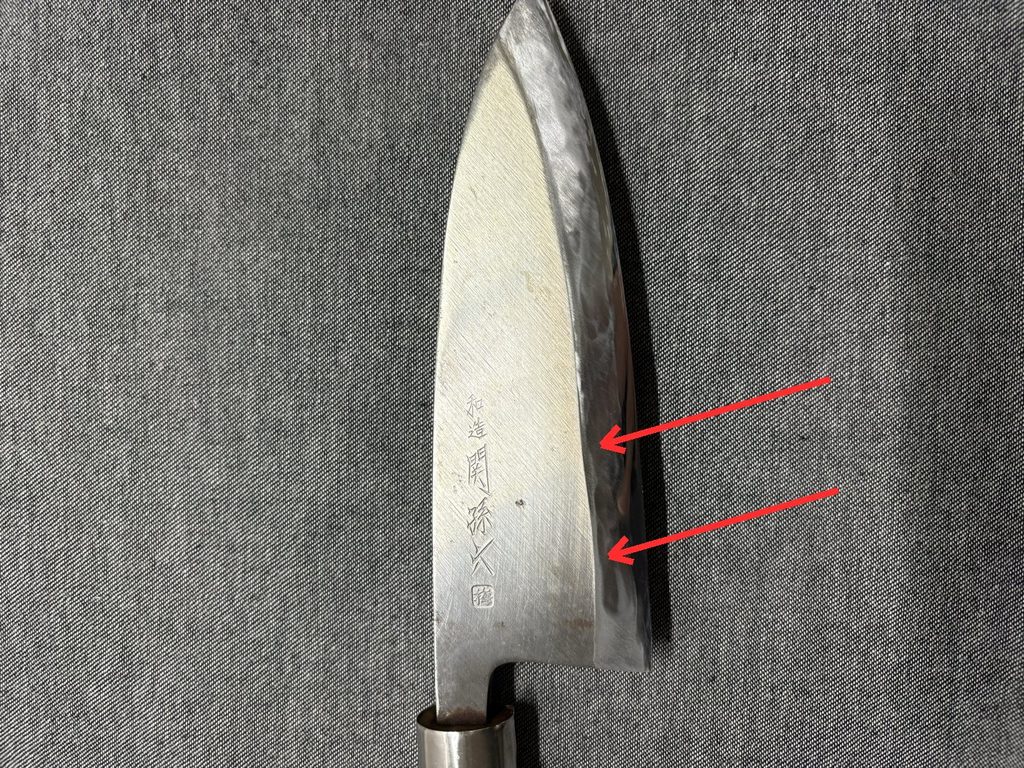 出刃包丁の中ほどから刃元にかけて、しのぎと刃線が波打って変形している箇所